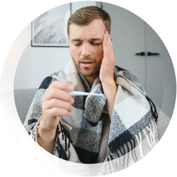 Man not feeling well and looking at a thermometer