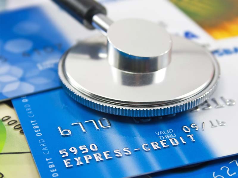 Doctor's stethoscope on top of a credit card